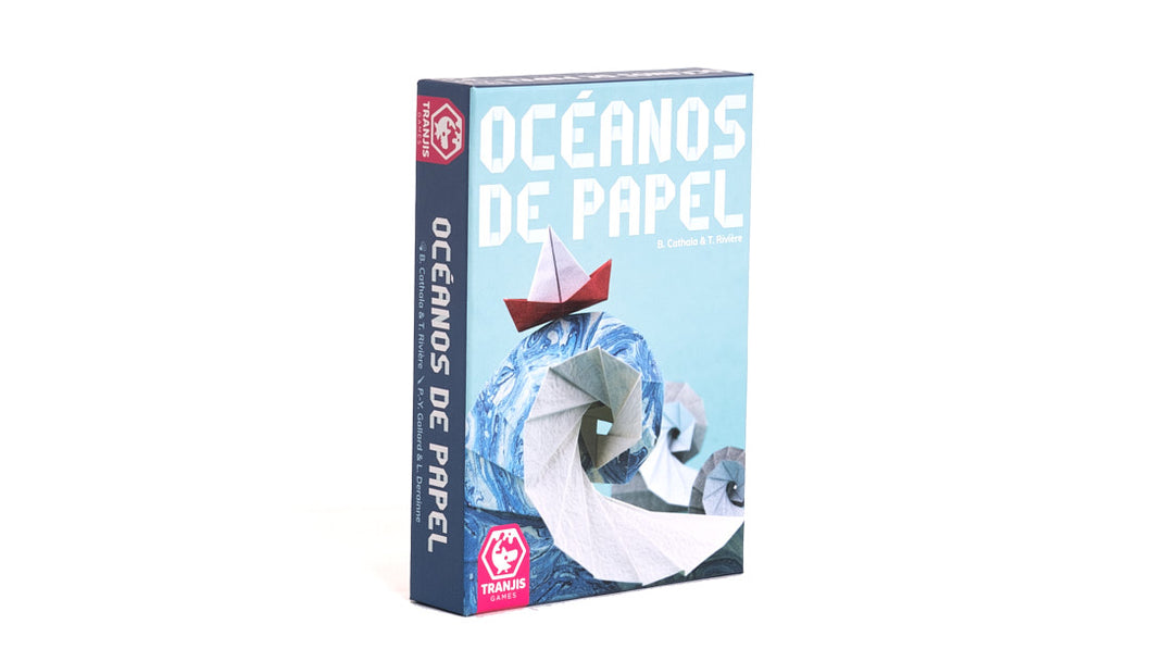 Caja del juego de mesa Océanos de papel en venta en ZZgames. Portada en tonos azules y con unas ilustraciones de papiroflexia. Un barco de papel surca unas olas en el mar de papel. El título centrado en la parte superior.